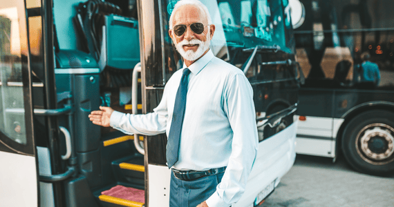 A bus driver greets passengers and welcomes them aboard 